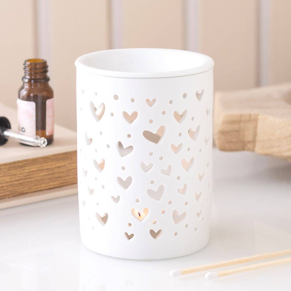 Quemador de cera blanco, con diseño recortado en forma de corazón